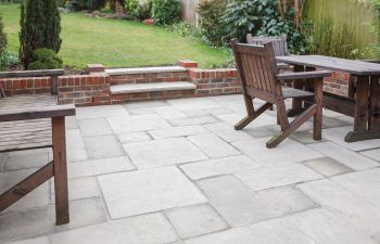 Backyard flagstone patio with garden furniture.