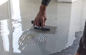 Construction workers are painting the floor using the method self-leveling epoxy