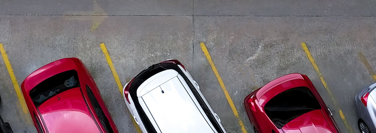 Cars parked on a concrete parking lot.
